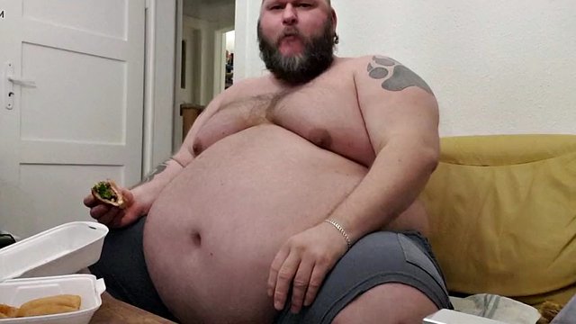 Superchubby SOC: ragazzo grasso che mangia un grosso hamburger e anelli di cipolla